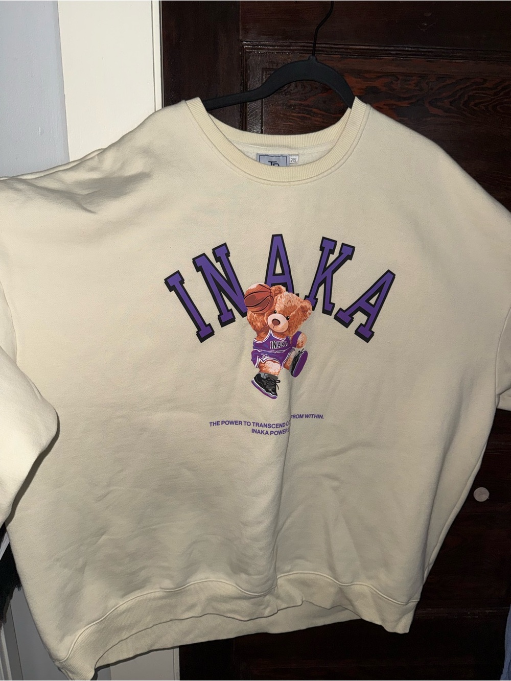 Inaka Power Cream Crewneck Sweatshirt with Purple Lettering and Bear Graphic